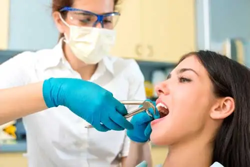 A woman getting a tooth extraction procedure at the clinic